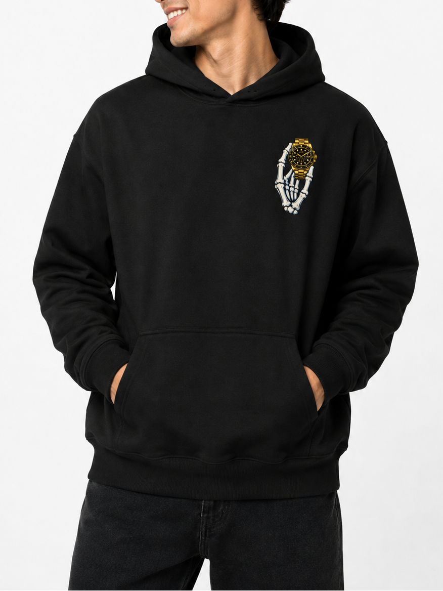 A man wearing a black pullover hoodie with a small graphic on the left chest, posed against a clean white studio background.