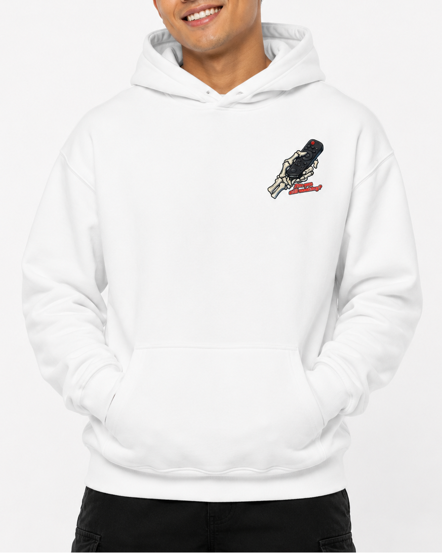 A smiling man wearing a white pullover hoodie with a small black and red bird graphic on the left chest, posed against a clean white studio background.