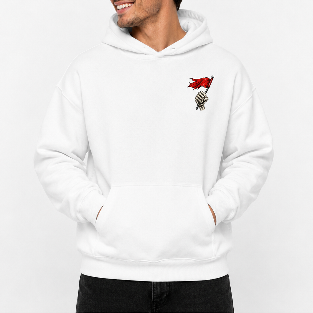 A man wearing a white pullover hoodie with a small red and black graphic on the left chest, standing against a plain white background.